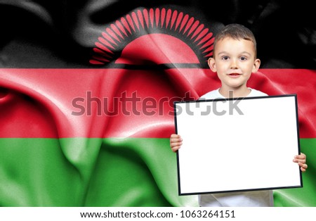 Cute small boy holding emtpy sign in front of flag of Malawi