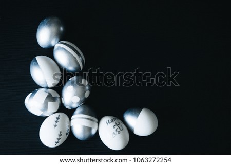 Group of diverse silver Easter eggs on black background, original stylish idea, selective focus, copy space