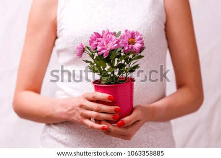 Image of woman holding pot with pink flower