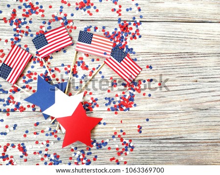 American independence Day, celebration, patriotism and holidays concept - flags and stars on the 4th of July party on top on wooden background