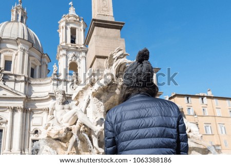 Horizontal picture of young woman looking to the sculpture at Piazza Navona, important landmark of Rome, Italy
