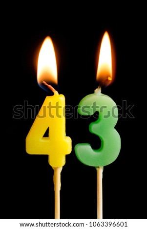 Burning candles in the form of 43 forty three (numbers, dates) for cake isolated on black background. The concept of celebrating a birthday, anniversary, important date, holiday, table setting