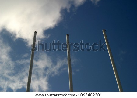 Empty flagpoles, without flags, against the blue sky 