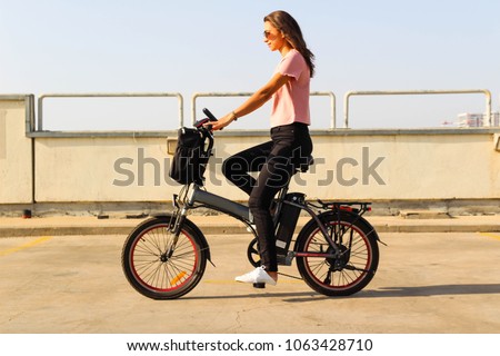 A young woman riding an electric bicycle