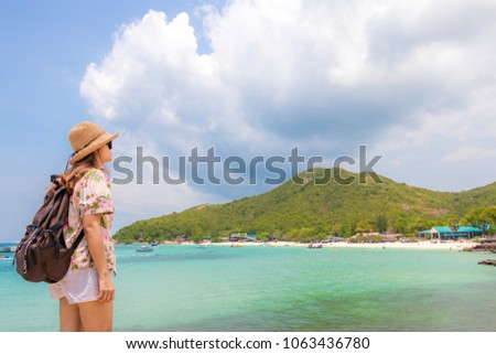 woman traveler with backpack and hat look at the Sea beach and background from “Koh larn“ in pattaya ,Thailand. Traveling Thailand.