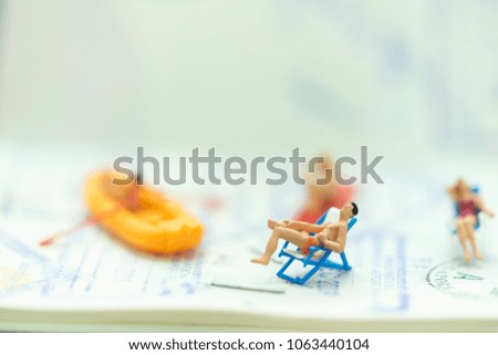 Miniature people: Passport with tourists using as background traveling, exploring the world, business travel trip concept.