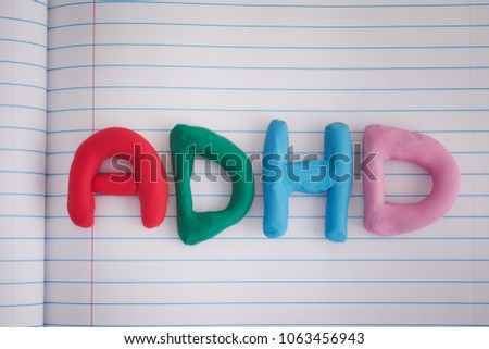 ADHD. Abbreviation ADHD made out of plasticine on notebook sheet. Close up. ADHD is Attention deficit hyperactivity disorder.