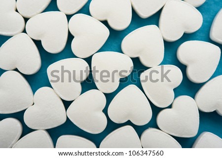 Pills as a heart on blue background