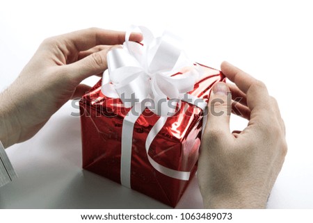 Man's hands give you a gift box closeup