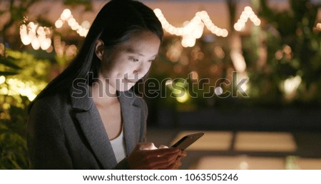 Business sending sms on smart phone at night 