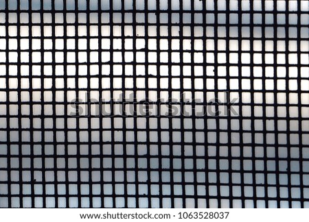 Grid pattern from wire screen on the window for background.