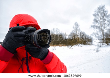 Unidentified man takes a picture on professional camera on a cold winter day