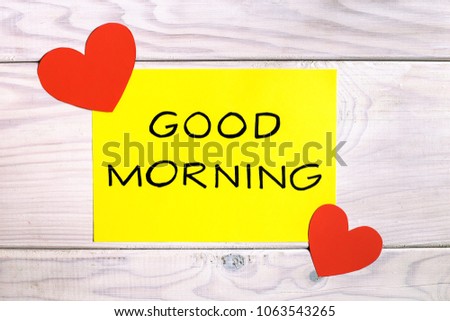 Text good morning with heart shapes on wooden table.Image is intentionally toned.