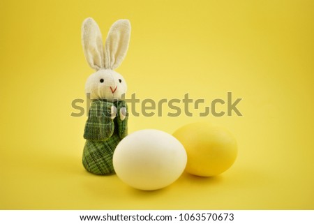 White rabbit toy stock images. Easter bunny on a yellow background. Easter rabbit with egg. Spring decoration images. Easter concept