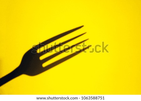 fork. fork and its shadow isolated on a yellow background
