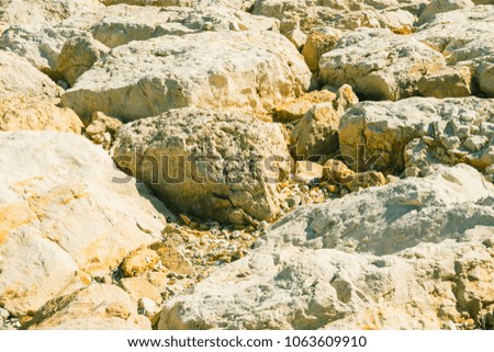 Abstract art background, closeup view of bright tropical seascape old rocks and stone wall. Ocean, waves, sky, clouds and islands