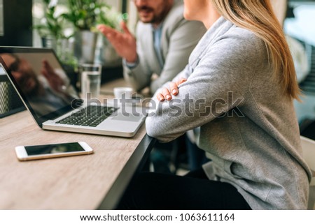 Two young business people sitting at table in cafe. Close-up
