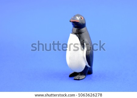Penguin toy stock images. Penguin toy on a blue background. Penguin figurine