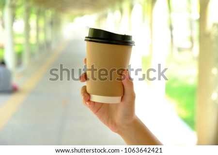 Paper cup of hot drink in hand Royalty-Free Stock Photo #1063642421