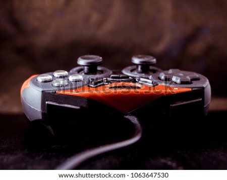 red and black game joystick close up shot