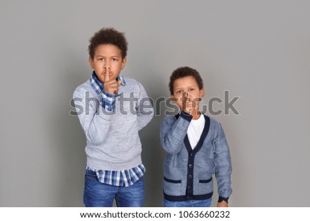Two boys in casual clothes studio isolated on grey wall silence