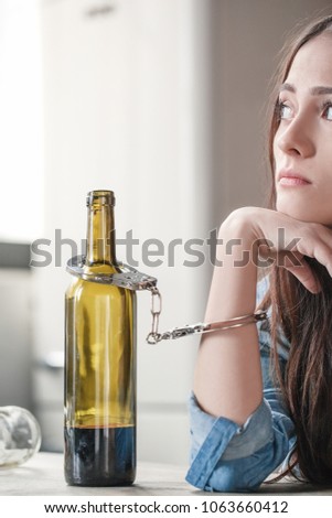 Young woman alcoholic social problems concept sitting fasten to wine bottle thoughtful