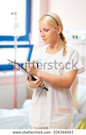 Portrait of a doctor or nurse writing something on notepad.