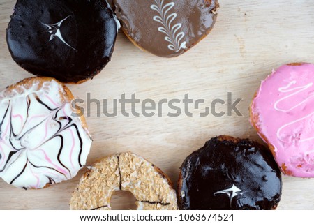 Flat lay various type of doughnut on a wooden surface