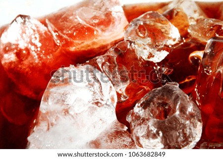 Soft drink with ice cube as background