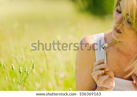 Picture of Innocence -Young girl blowing on a dandelion to make a wish.
