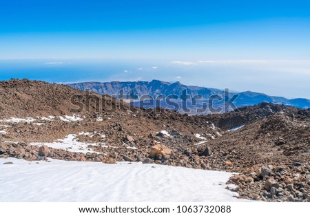 Arid volcanic landscape of snow covered Mount Pico del Teide in Teide National Park, Tenerife