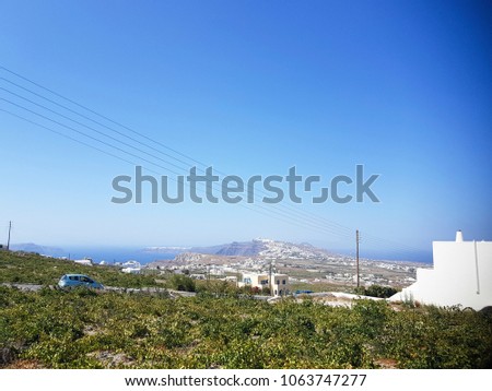 Landscape view of fields, vineyards and greek villages Fira and Oia on Santorini island, Greece. Vines grown mainly for winemaking, but also raisins, table grapes and non alcoholic grape juice. 