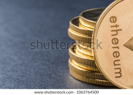 Golden virtual money Ethereum crypto currency coins stacked on a dark background