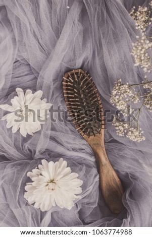 Haircare concept. Natural sandalwood comb closeup on tender background