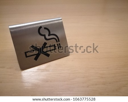 Metal no smoking sign on wooden table