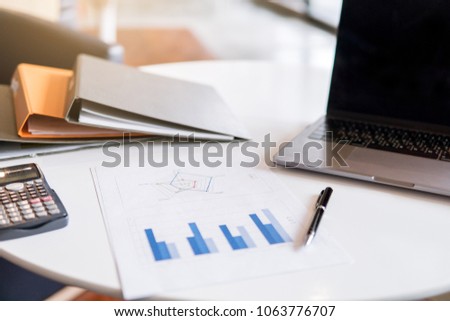 Equipments used for working or learning such as laptop or computer notebook, papers, pens or pencils, calculator, phone, files or folders for keeping documents. With blurry background.
