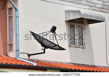 Satellite dish is attached to the wall of the house