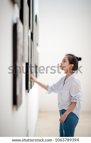 woman looking at the pictures on the wall
