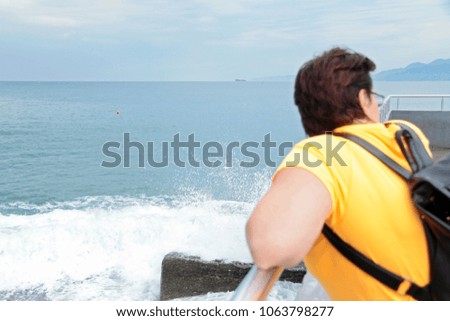Woman with backpack standing on the seashore