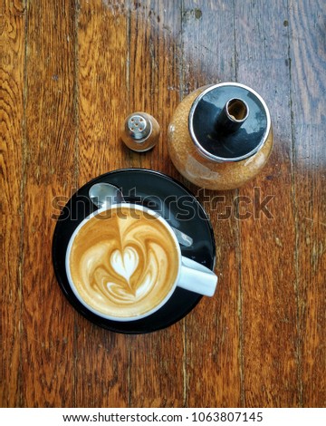cappuccino cup art heart shape with brown sugar and chinnamon, on wooden table top view