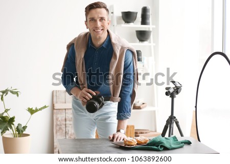 Young man with professional camera in photo studio