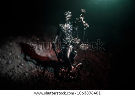 The Statue of Justice - lady justice or Iustitia / Justitia the Roman goddess of Justice on a dark fire background. Selective focus