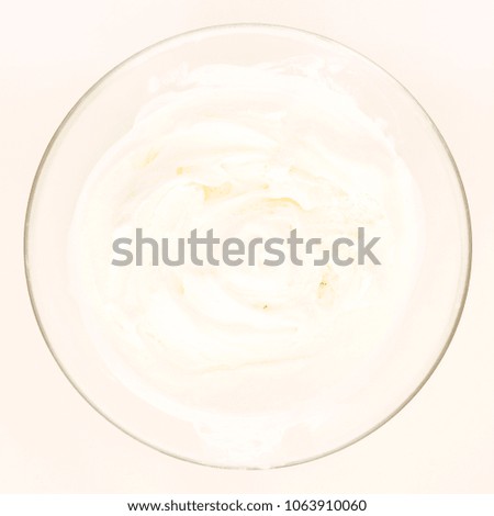 Ice cream on a glass plate on a white table. The view from the top.