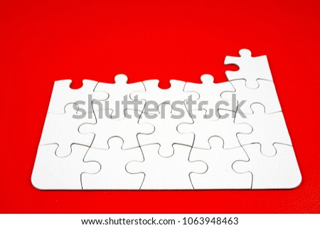 Image of piece of white puzzle number one to twenty five over red background