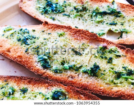 Toasts with basil and garlic close-up on a plate