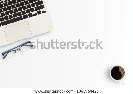 Office desk or workspace with laptop computer,cup of coffee and glasses with copy space on white table background. Top view. Flat lay style.