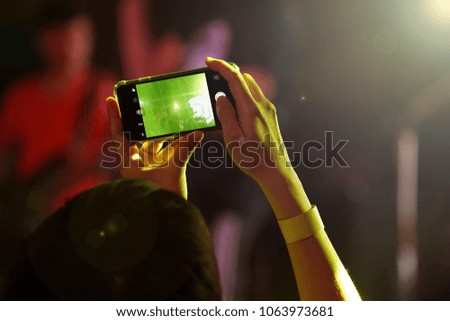 Audience keep taking photo and video at concert with their cellphone focus on the screen with blur background