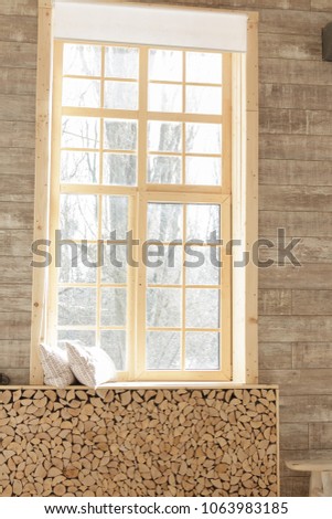 Very large windows with wooden frames in a light beige wooden living room. Scandinavian style