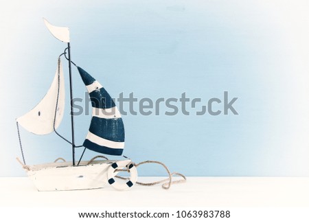 nautical concept with sail boat over white wooden table.
