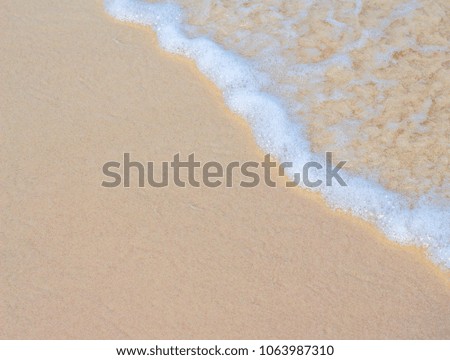 Sea wave and white sand beach photo background. Sunny beach sand with sea wave. White sand of oceanic coastline. Exotic island seaside banner template with place for text. Tropical seashore foamy wave